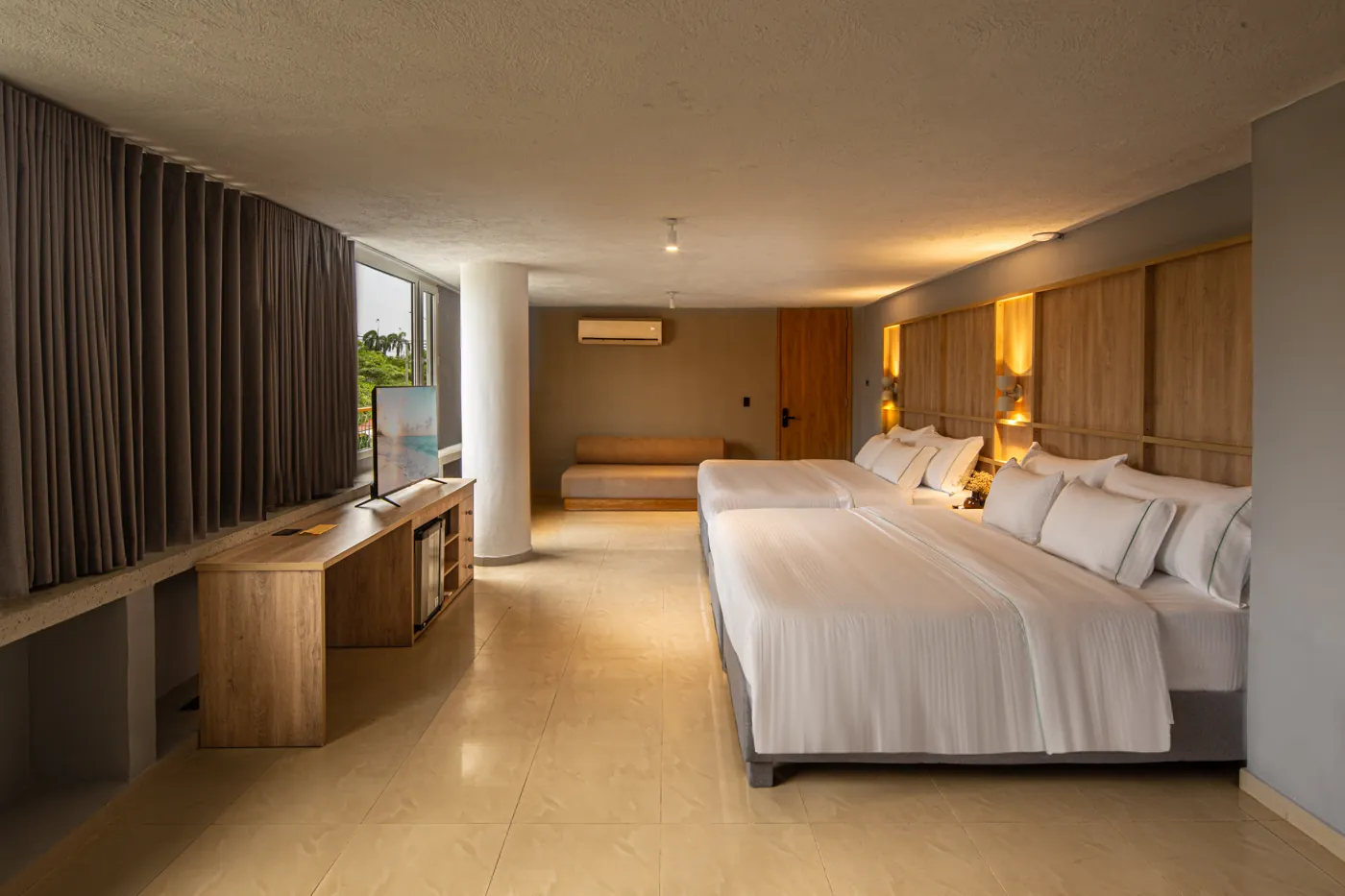 Habitación Luxury Family de Mood Matuna Hotel con dos camas king y ventanal